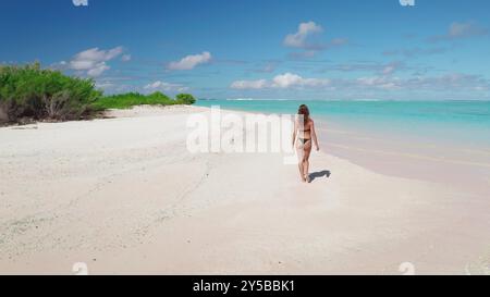 Jeune femme en bikini marchant plage de sable blanc parfaite, ciel bleu, eau turquoise. Slim caucasien femme se détendre, profiter de voyage de style de vie en plein air sur les vacances d'été, Maldives île tropicale. Banque D'Images