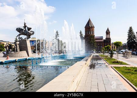 Gyumri, Arménie - 20 juillet 2024 : chemin près de la fontaine sur la place Vardanants avec Mémorial de la bataille d'Avarayr et l'église du Saint-Sauveur à Gyumri ci Banque D'Images