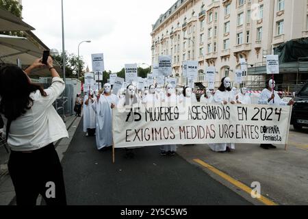 Des femmes vêtues de robes blanches et de masques lors d’une manifestation pour exiger la fin de la violence sexiste devant le Congrès des députés à Madrid le 21 septembre Banque D'Images