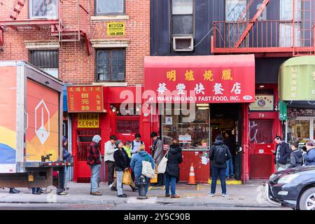 New York, États-Unis - 21 septembre 2024 : les clients se sont rassemblés devant le vibrant Wah Fung No. 1 Fast Food parmi les bâtiments typiques de Chinatown. Banque D'Images