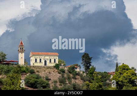 Ciel orageux au-dessus d'une église orthodoxe grecque avec un grand nuage noir au-dessus de la colline dans la ville de Zakynthos Grèce Banque D'Images