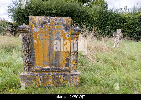 Pierre tombale recouverte de lichen dans le cimetière de l'église Saint-Nicolas-de-Mira, Steeple Langford, Wiltshire, un bâtiment classé Grade ll. Banque D'Images