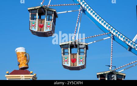 Munich, Allemagne. 21 septembre 2024. Les gondoles vides de la grande roue se trouvent devant la tasse à bière surdimensionnée d'un chapiteau. L'Oide Wiesn se déroule en même temps que l'Oktoberfest du 21 septembre au 6 octobre 2024. Crédit : Stefan Puchner/dpa/Alamy Live News Banque D'Images