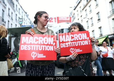 Deux manifestants tenant des pancartes avec le message "Macron impeachment", lors de la manifestation depuis la place Bastille. Plusieurs associations de jeunes, écologiques et féministes ont lancé un appel à manifester contre la nomination de Michel Barnier à la tête du gouvernement par Emmanuel Macron, qu’elles considèrent comme un « déni de démocratie ». Cela fait suite à la demande de destitution du président lancée par l’union de la gauche et validée par le bureau de l’Assemblée nationale, le 21 septembre 2024 à Paris. Photo Christophe Michel/ABACAPRESS. COM Banque D'Images