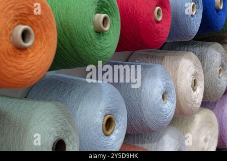 Bobines de fils de laine multicolores, fond abstrait de l'industrie textile Banque D'Images