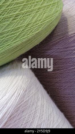 Bobines de fils de laine multicolores, fond abstrait de l'industrie textile Banque D'Images