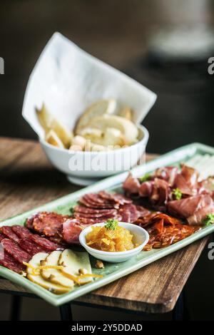 Viandes fumées traditionnelles espagnoles, chorizo de jambon serrano et plateau de fromage plat d'entrée avec confiture de coings et pain Banque D'Images