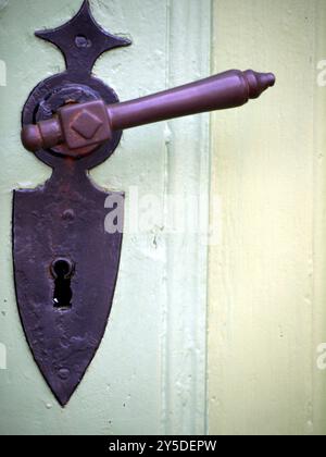 Poignée de porte sur vieille porte en bois vert clair Banque D'Images