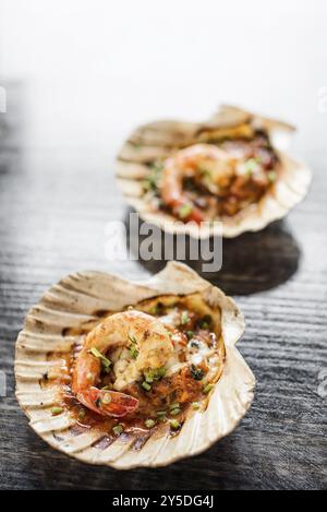 Cuisine gastronomique aux crevettes royales cuites dans une sauce épicée aux tomates et aux herbes Banque D'Images