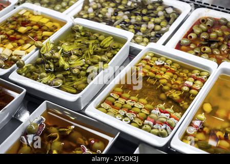 Des collations à tapas mixtes aux olives dans les plateaux d'exposition du marché de la boqueria à barcelone en espagne Banque D'Images