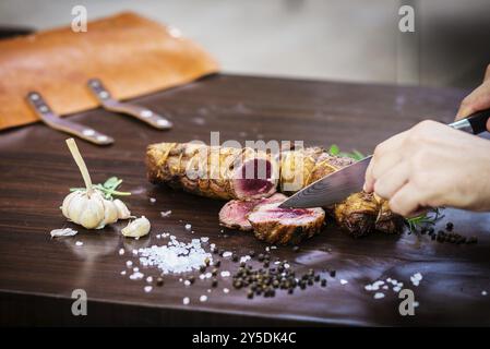 Repas roulé à la viande de porc rôti sculpté dans un style rustique avec assaisonnements Banque D'Images