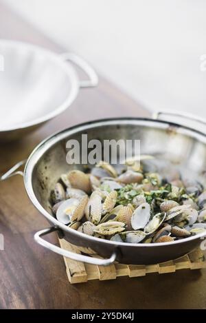 Moules cuites à la vapeur style bulhao pato avec sauce à l'ail et aux herbes dans la cataplana portugaise Banque D'Images