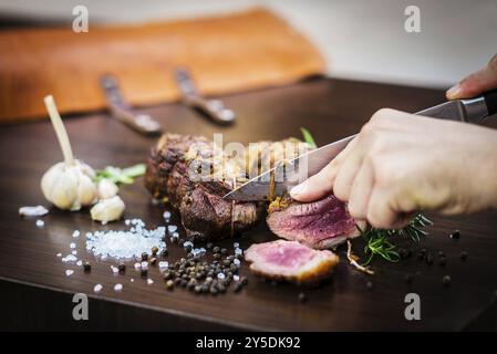 Repas roulé à la viande de porc rôti sculpté dans un style rustique avec assaisonnements Banque D'Images