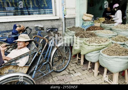 Cyclo chauffeurs de taxi et magasin d'herbes dans la rue de la ville de saigon ho chi minh au vietnam Banque D'Images