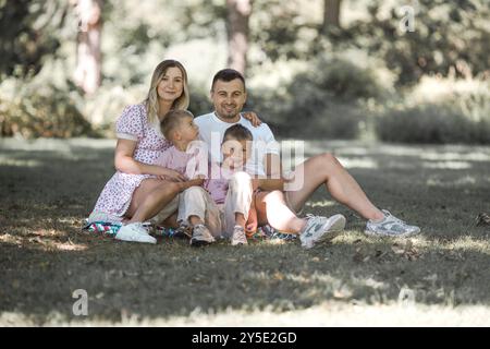 Livraison de baiser pour papa et maman. Photo recadrée d'une jeune famille passant du temps ensemble à l'extérieur. Banque D'Images