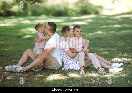 Livraison de baiser pour papa et maman. Photo recadrée d'une jeune famille passant du temps ensemble à l'extérieur. Banque D'Images