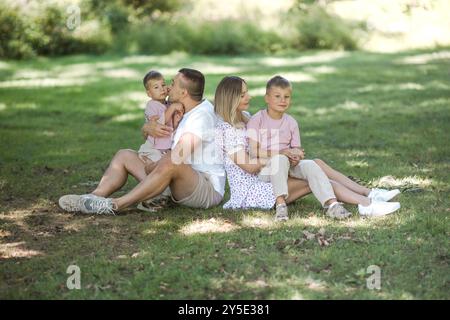 Livraison de baiser pour papa et maman. Photo recadrée d'une jeune famille passant du temps ensemble à l'extérieur. Banque D'Images