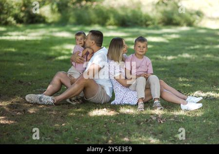 Livraison de baiser pour papa et maman. Photo recadrée d'une jeune famille passant du temps ensemble à l'extérieur. Banque D'Images