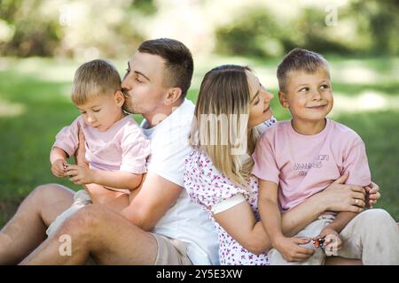 Livraison de baiser pour papa et maman. Photo recadrée d'une jeune famille passant du temps ensemble à l'extérieur. Banque D'Images