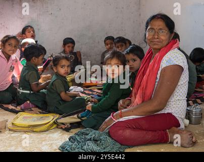 Professeur indien assis avec des élèves dans une salle de classe rurale Banque D'Images