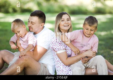 Livraison de baiser pour papa et maman. Photo recadrée d'une jeune famille passant du temps ensemble à l'extérieur. Banque D'Images