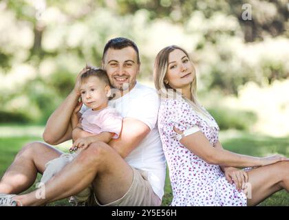 Livraison de baiser pour papa et maman. Photo recadrée d'une jeune famille passant du temps ensemble à l'extérieur. Banque D'Images