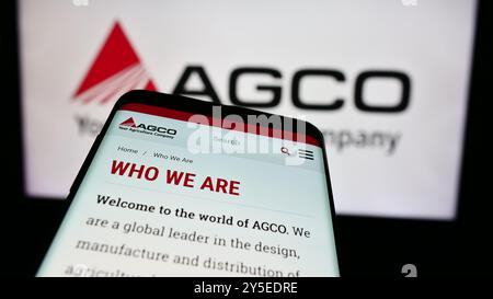 Sur cette illustration photo, un smartphone avec le site Web de la société américaine de machines agricoles AGCO Corporation est visible devant le logo de l'entreprise. Banque D'Images
