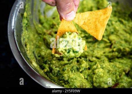 Guacamole à l'avocat traditionnel et assaisonnements classiques avec des nachos tortilla de maïs Banque D'Images