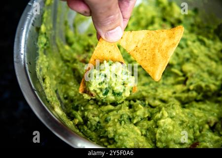 Guacamole à l'avocat traditionnel et assaisonnements classiques avec des nachos tortilla de maïs Banque D'Images