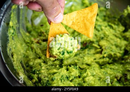 Guacamole à l'avocat traditionnel et assaisonnements classiques avec des nachos tortilla de maïs Banque D'Images