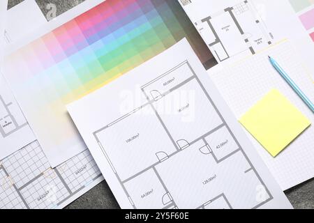 Lieu de travail du designer avec plans de maison, palettes de couleurs et papeterie sur table, pose à plat Banque D'Images