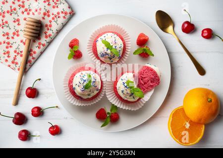 Muffins en velours rouge avec glaçage sucré et caramel. Banque D'Images