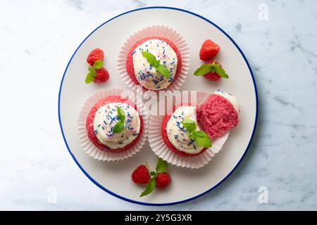 Muffins en velours rouge avec glaçage sucré et caramel. Banque D'Images