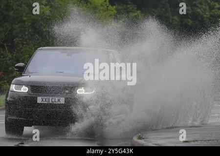 Un Range Rover conduisant dans une flaque au rond-point de Braywick à Maidenhead. Les orages et les fortes pluies persisteront dans certaines parties du Royaume-Uni, alors que l'été touche officiellement à sa fin. Samedi, le tonnerre et la foudre, la grêle et la pluie ont frappé diverses régions du pays, notamment Luton, Bedfordshire, St Albans dans le Hertfordshire et Cornwall, avec de fortes pluies à Londres, au pays de Galles et à Birmingham. Date de la photo : dimanche 22 septembre 2024. Banque D'Images