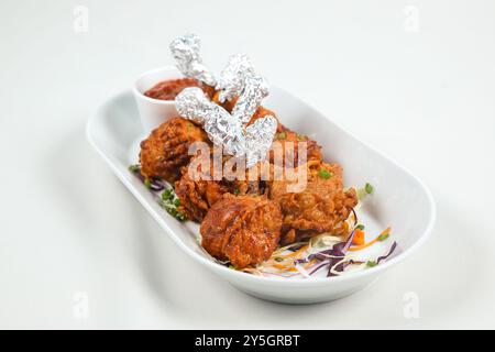 Sucette au poulet. Sucette de poulet frite garnie de coriandre verte et fraîche et d'épices. Banque D'Images