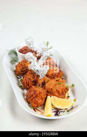 Chicken Lollipop est un apéritif chinois indien qui est une ailette de poulet frenched. enveloppé avec du papier d'aluminium argenté à une extrémité et servi avec du chutney. Banque D'Images