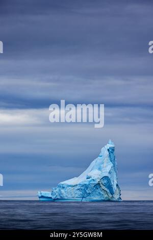 Iceberg bleu dans les eaux froides et bleues de l'océan Arctique à l'île Bontekoe, dans le parc national du nord-est du Groenland. Banque D'Images