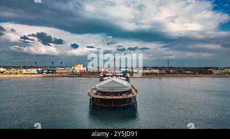 Une vue panoramique sur une jetée s'étendant dans la mer calme, avec un ciel nuageux au-dessus. La jetée présente un auvent blanc et est entourée d'eau. À l'arrière Banque D'Images