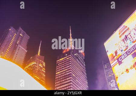 Vue nocturne des gratte-ciel, y compris le bâtiment HM, avec des panneaux d'affichage numériques lumineux à Times Square, New York City. ÉTATS-UNIS. Banque D'Images