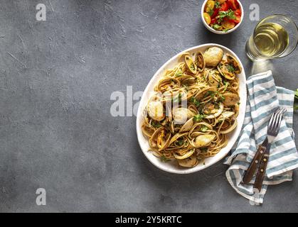 Pâtes aux fruits de mer. SPAGHETTI ALLE VONGOLE ITALIENNES. Palourdes spaghetti sur plaque blanche avec du vin blanc, fond gris. Vue d'en haut Banque D'Images