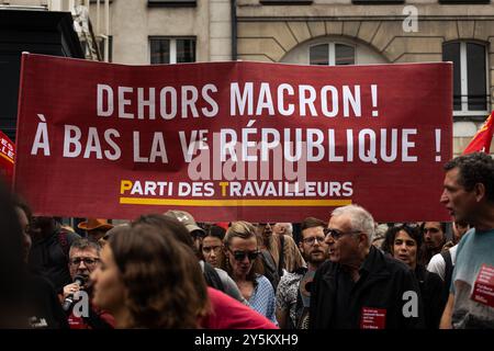 Paris, France. 22 septembre 2024. Une pancarte qui dit "Macron dehors : à bas la cinquième République" vue au milieu de la foule lors de la manifestation contre le nouveau gouvernement Macron-Barnier, à Paris. Quelques heures avant l'annonce du nouveau gouvernement du premier ministre français Michel Barnier, des milliers de personnes ont manifesté à Paris pour réclamer la destitution du président Emmanuel Macron. L’appel à des manifestations de masse à travers la France est venu du parti de gauche la France insoumise, ainsi que d’écologistes et d’associations étudiantes et féministes. Crédit : SOPA images Limited/Alamy Live News Banque D'Images