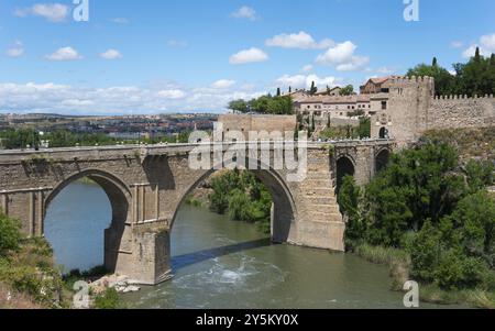 Pont de pierre historique sur la rivière dans un cadre rural avec les bâtiments anciens voisins, Puente de San Martin, Saint Martin's Bridge, Tolède, Tage, Banque D'Images