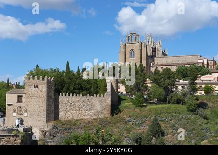 Paysage urbain médiéval avec église, remparts et arbres sous un ciel bleu avec nuages, Puente de San Martin, Pont St Martin, monastère sur la droite, Banque D'Images