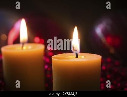 2 bougies allumées devant les décorations de Noël Banque D'Images