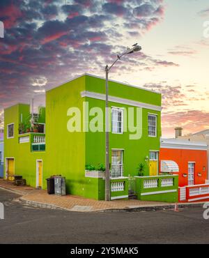 Bâtiments sur un coin, avec un ciel de coucher de soleil spectaculaire en arrière-plan, mettant en valeur la beauté architecturale et les teintes vibrantes dans la mélodie culturelle de Bo-Kaap Banque D'Images