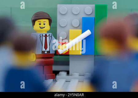 Tambov, Fédération de Russie - 21 septembre 2024 figurines Lego hommes d'affaires ayant une réunion et discutant des graphiques montrant les résultats de leur su Banque D'Images