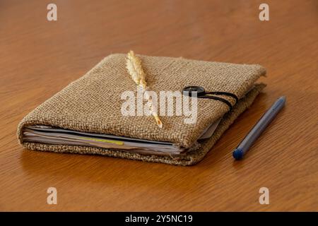 Cahier fait à la main marron avec couverture en toile de jute et oreille de blé se trouve sur la table, cahier fait à la main Banque D'Images