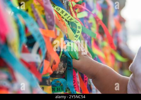 Salvador, Bahia, Brésil - 27 décembre 2019 : les mains des catholiques touchent les rubans colorés du souvenir de l'église de Senhor do Bonfim In Banque D'Images