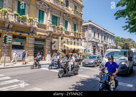 Messina Sicile Italie, via Giuseppe Garibaldi, extérieur, coureurs de scooter à moteur, hommes femme, vélo électrique, véhicules de circulation, construction d'appartements résidentiels Banque D'Images