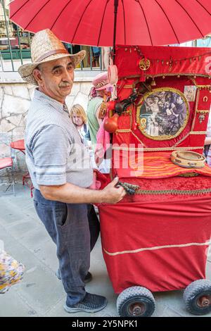 Corfou Grèce, vieille ville, rue Maniarizi Arlioti, broyeur d'orgue de baril, conseils de jeu, homme portant chapeau de paille, Europe grecque européenne UE, visite de voyage des visiteurs t Banque D'Images